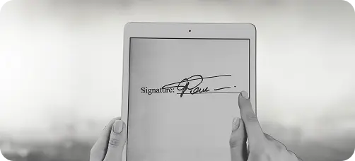 Persoon zet digitale handtekening op tablet als onderdeel van juridisch document bij The Law Firm.